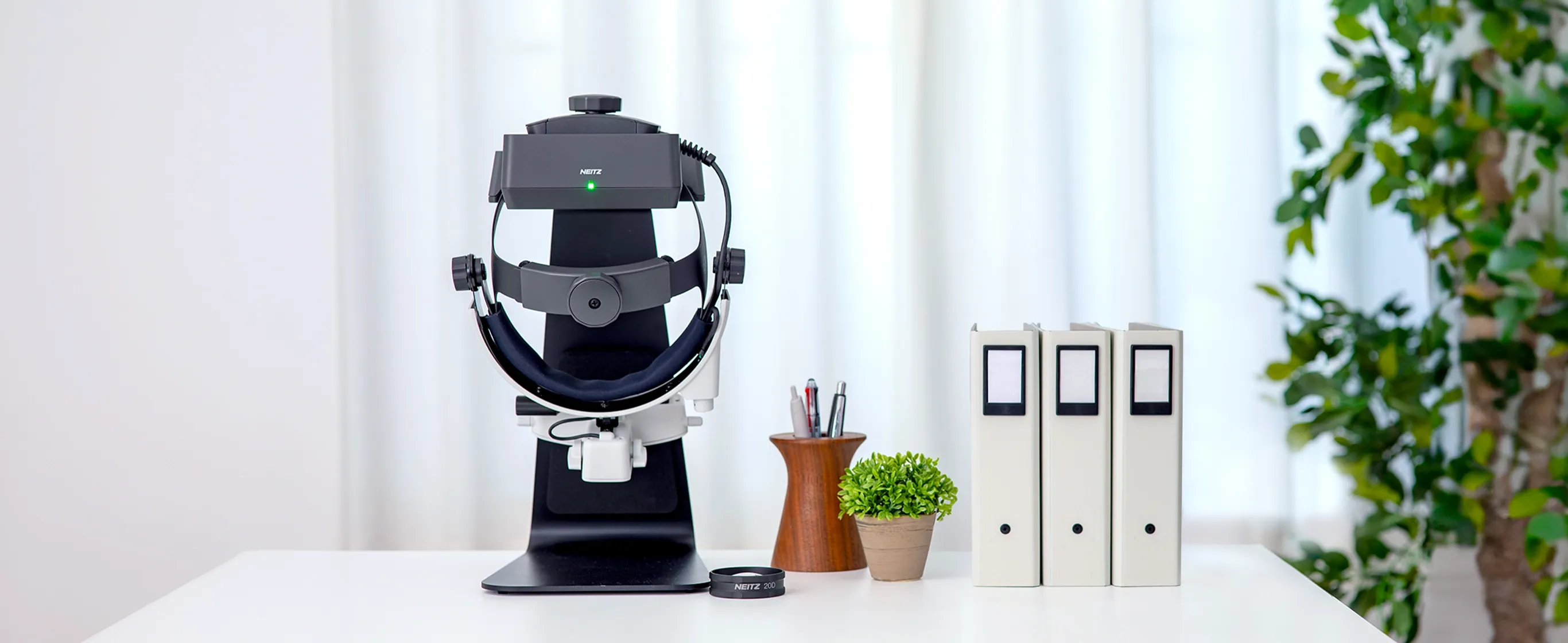 IO-Vega binocular indirect ophthalmoscope on charging stand in a clinical setting